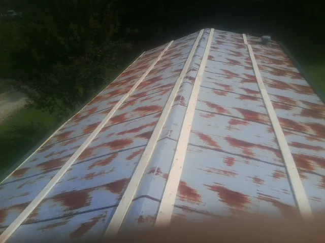 Rusted metal roof panels with new wood purlins before replacement — Storm Damage Roof Repair in Parowan by Roofing Brothers